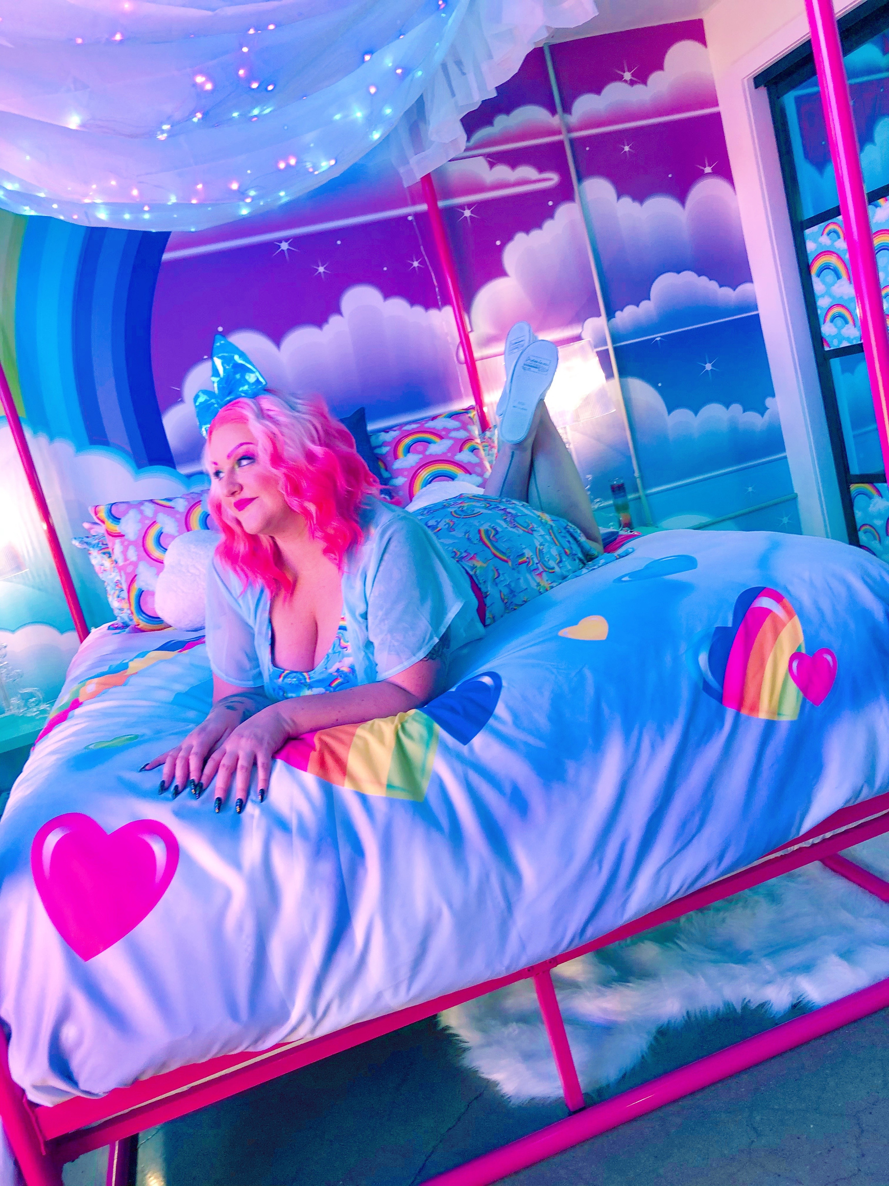 roxy tart with pink hair laying on a bed in a lisa frank bedroom